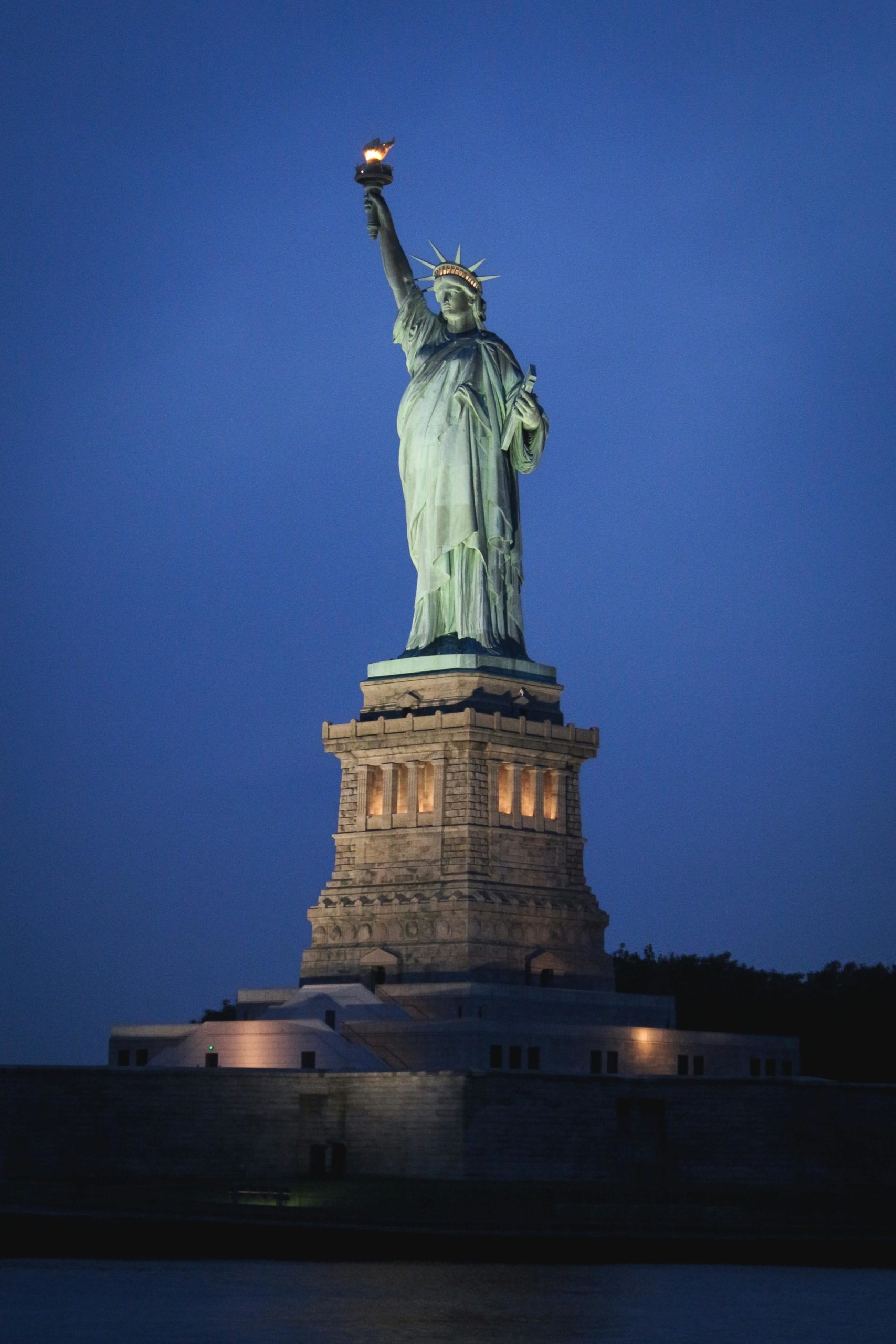 Stunning nighttime view of the Statue of Liberty on Liberty Island, New York City.